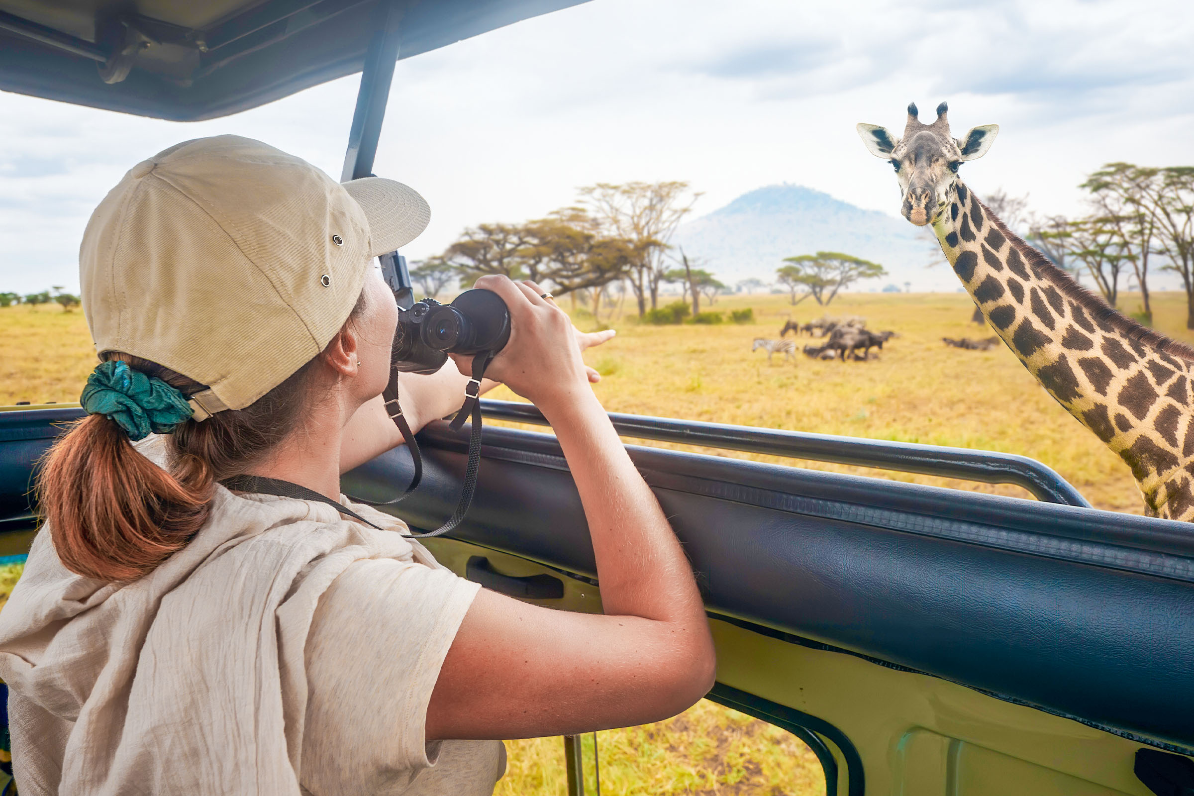 Young-woman-watching-a-giraffe-on-safari-in-Serengeti-National-Park-Tanzania-1